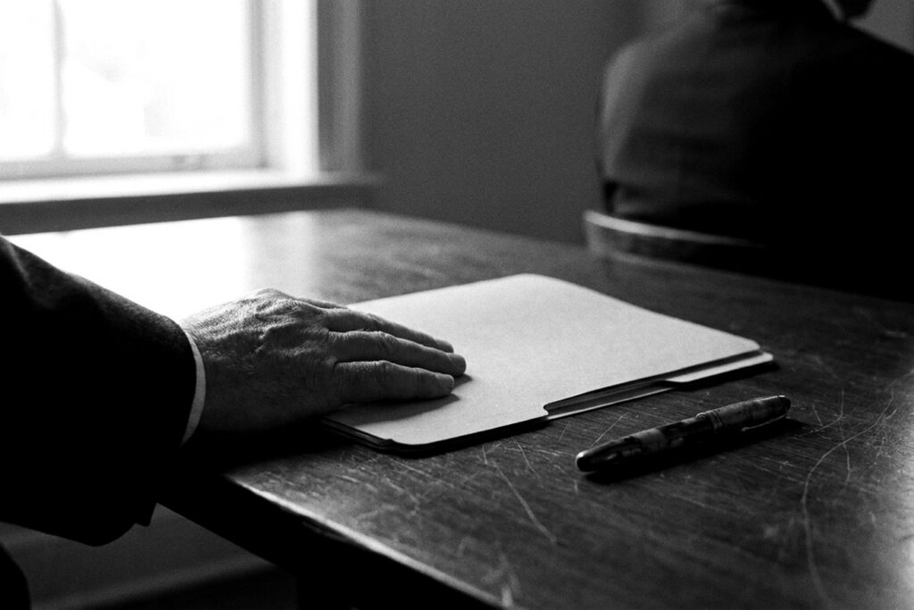 Main posée sur un dossier prêt à être transmis, symbole d'une mission RH externalisée
