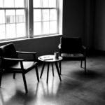 Deux fauteuils vides face à face dans une salle de réunion en noir et blanc — change management