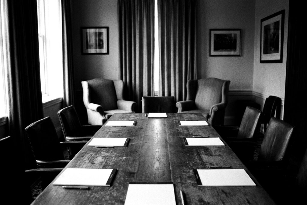 Table de réunion en bois dans une salle de direction, noir et blanc — conseil en management